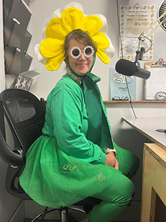 woman in green dress and yellow hat resembling a yellow flower